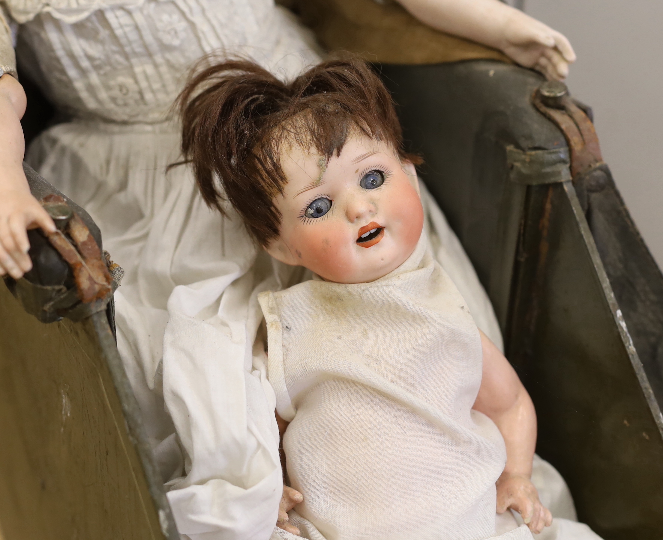 An Armand Marseille open mouth doll, a Heubach Koppelsdorf open mouth doll and an upright dolls pram, pram 66cm high